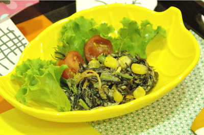 葉っぱの形をした黄色の深皿にひじきと季節野菜たっぷりのサラダが盛り付けられている写真