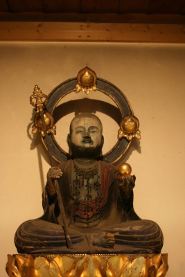 右手に錫杖、左手に黄金の宝珠を持って安坐する木造地蔵菩薩座像の写真