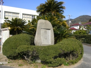 緑の木々の植栽の中心にある岩田遺跡の石碑を写した写真