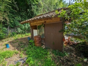 庭に一部残された小屋のようなものが建っている様子の写真