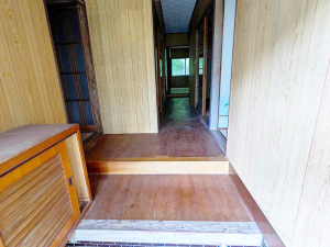 左側に靴箱があり、玄関から上がるとまっすぐに廊下が伸びている玄関から見た室内の写真